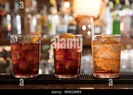 Primo piano di un banco di bar, tre cocktail rinfrescanti pronto a servire, spritz e cocktail americano Foto Stock