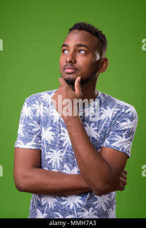 Bel giovane uomo africana contro lo sfondo di colore verde Foto Stock