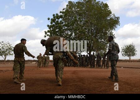 Stati Uniti Esercito di soldati di fanteria dal decimo Montagna divisione e 3-144 Reggimento di Fanteria treno membri del Gibuti Forze Armate (FAD) assegnata per il rapido intervento battaglione sul combattimento casualty care a Gibuti il 10 maggio 2018, 10 maggio 2018. I membri della nervatura passare attraverso cinque settimane di corso combatives di copertura, armi e combattere le abilità salvavita. (U.S. Air Force foto di Airman 1. Classe Haley D. Phillips). () Foto Stock