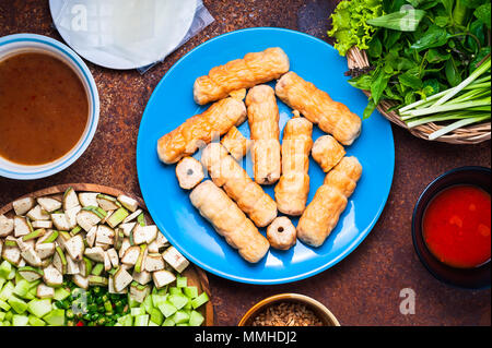 Vietnamita involtini di polpette ( Nam Neung ) servita con verdure, salsiccia sul tavolo rustico. Lay piatto Foto Stock