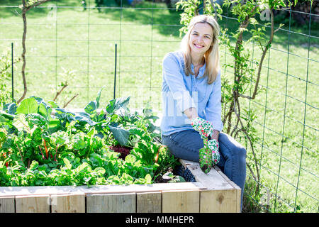 Giardinaggio - donna felice è orgogliosa del proprio letto sollevata Foto Stock