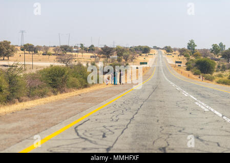 Povera gente che camminava sul ciglio della strada nelle zone rurali Caprivi Strip, la più popolosa regione in Namibia, Africa. Foto Stock