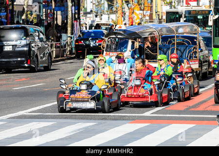 Tokyo, Shibuya crossing. Popolari attività turistiche, guida MariCars, Mario Kart mentre vestita come Mario caratteri. Fila di attesa in attraversamento. Foto Stock