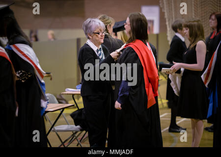 Laureate essendo vestito in abiti, cappucci e tappi / Mortarboards per la cerimonia di laurea - Università di Chester, Inghilterra Foto Stock