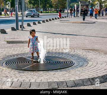 Bambina gioca con fontana di acqua al di fuori del Mercato Centrale, edificio Santiago del Cile Foto Stock