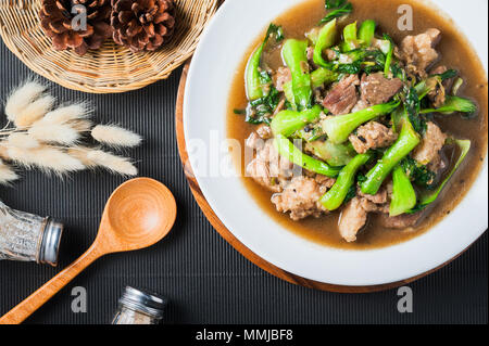 Saltate in padella cavolo cinese ( Cavolo cinese di verdura verde ) con carne di maiale , aglio e salsa di soia in bianco piatto sul tavolo, cotti pronti a servire. Foto Stock