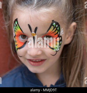 Close up della ragazza con farfalla dipinto sul volto Foto Stock