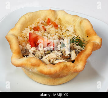 Filetto di pollo con julienne di funghi (filetto di pollo con julienne di funghi, risotto con verdure, originale con sede di servizio in un cestello realizzato dal pane di grano Foto Stock