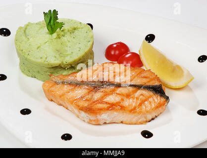 Bistecca di salmone servito con purè di patate, broccoli e pomodori ciliegini. Foto Stock