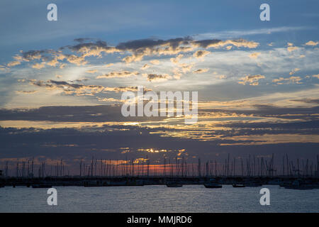 Yacht ormeggiati per la notte in St Kilda Bay come il sole tramonta sulla baia. Foto Stock