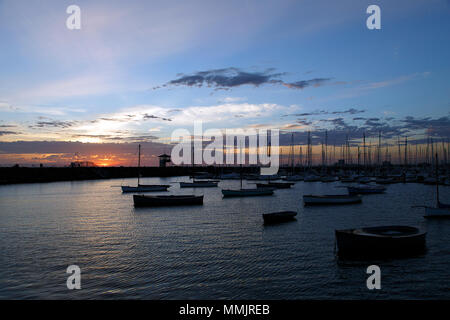 Yacht ormeggiati per la notte in St Kilda Bay come il sole tramonta sulla baia. Foto Stock