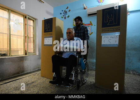 Baghdad in Iraq. Il 12 maggio 2018. Un uomo iracheno si prepara a gettare il suo voto durante le elezioni parlamentari in corrispondenza di una stazione di polling a Baghdad, Iraq, 12 maggio 2018. Quasi 7.000 candidati sono in lizza per i posti a sedere in 329-Parlamento forte, che saranno in seguito eleggere Iraq·s presidente e primo ministro. Credito: Ameer Al Mohammedaw/dpa/Alamy Live News Foto Stock