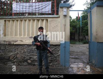 A Kabul, Afghanistan. Il 12 maggio 2018. Un poliziotto afghano sta di guardia al di fuori di una registrazione degli elettori center a Kabul, capitale dell'Afghanistan, 12 maggio 2018. Le elezioni afghane Commission (IEC) ha esteso la registrazione degli elettori per il lungo ritardo parlamentare e consigli di distretto' elezioni previste per ottobre in 20, per consentire più elettori eleggibili per registrare, il CEI detto venerdì. Credito: Rahmat Alizadah/Xinhua/Alamy Live News Foto Stock