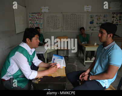 A Kabul, Afghanistan. Il 12 maggio 2018. Un uomo afghano colloqui con una commissione elettorale lavoratore (L) in corrispondenza di una registrazione degli elettori center a Kabul, capitale dell'Afghanistan, 12 maggio 2018. Le elezioni afghane Commission (IEC) ha esteso la registrazione degli elettori per il lungo ritardo parlamentare e consigli di distretto' elezioni previste per ottobre in 20, per consentire più elettori eleggibili per registrare, il CEI detto venerdì. Credito: Rahmat Alizadah/Xinhua/Alamy Live News Foto Stock