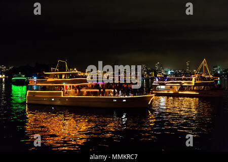 Sydney, Australia - 1 Gennaio 2015: riflettendo barche nella baia di Sydney in attesa di fuochi d'artificio per festeggiare il nuovo anno, girato da una barca in molto ventoso. Foto Stock