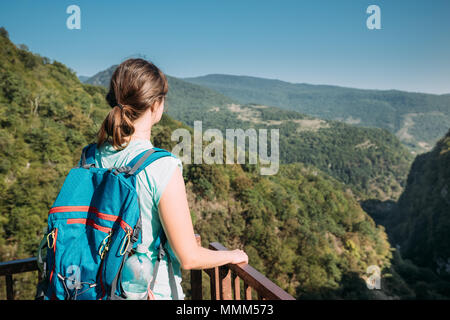 Zeda-gordi, Georgia. Vista posteriore della donna in piedi su stretto ponte di sospensione o pendente Road fino a 140 metri sopra il precipizio sul territorio Okatse Cany Foto Stock