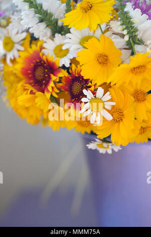 Bouquet di fiori selvatici in una benna viola Foto Stock