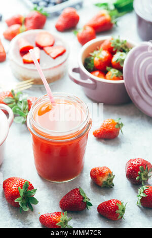 Vista frontale di fragola detox succo di frutti di bosco w all'interno della ceramica cocotte colorate, mirtilli, fragole, lamponi, piatto lay.Detox e sano Foto Stock