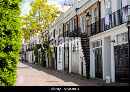 LONDON, Regno Unito - 10 Maggio 2018: Holland Park Mews è un acciottolate attraverso la strada si avvicinò attraverso il proprio arco off Holland Park nel Royal Borough of Kens Foto Stock