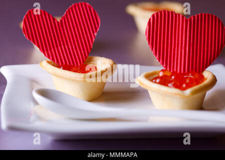 Tortine con caviale rosso e cuori di carta il giorno di San Valentino Foto Stock
