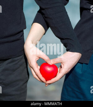 L uomo e la donna sono in possesso di un cuore rosso Foto Stock