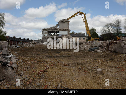 Demolizione controllata di edifici in cemento armato a più piani utilizzando Caterpillar Escavatore idraulico a portata elevata da 350L sul sito di demolizione di Bury regno unito Foto Stock