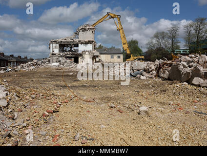 Demolizione controllata di edifici in cemento armato a più piani utilizzando Caterpillar Escavatore idraulico a portata elevata da 350L sul sito di demolizione di Bury regno unito Foto Stock