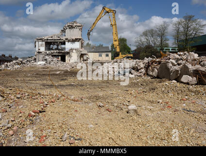 Demolizione controllata di edifici in cemento armato a più piani utilizzando Caterpillar Escavatore idraulico a portata elevata da 350L sul sito di demolizione di Bury regno unito Foto Stock