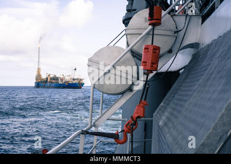 Vista dalla nave offshore ponte a mare aperto. FPSO nave cisterna è su sfondo. La Gru a gancio e zattere di salvataggio sono a fuoco Foto Stock