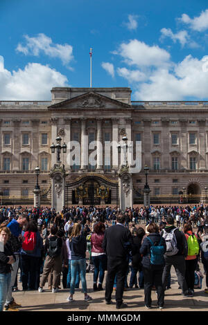 Un giorno di primavera fuori Buckingham Palace come le folle si radunano per visualizzare il Queen's home Foto Stock