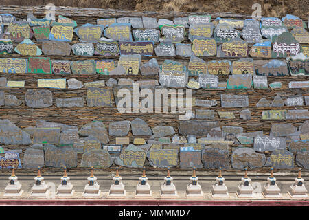 Mani lungo muro di pietra a Ser Gergyo (Ani Gompa) convento, Tagong, Sichuan, in Cina Foto Stock