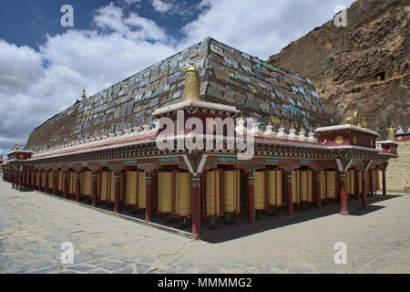 Mani lungo muro di pietra e ruote della preghiera presso la SER Gergyo (Ani Gompa) convento, Tagong, Sichuan, in Cina Foto Stock