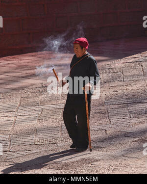 Pellegrino tibetano passeggiate kora cerchi intorno al santo Bakong scrittura Stampa Monastero a Dege, Sichuan, in Cina Foto Stock