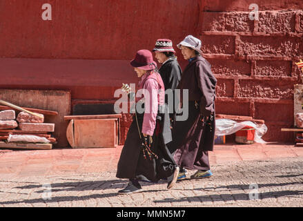 Pellegrini tibetani passeggiate kora cerchi intorno al santo Bakong scrittura Stampa Monastero a Dege, Sichuan, in Cina Foto Stock