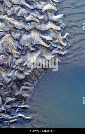 Onda-formate ondulazioni sinistra accanto a piscine di acqua di mare sulla spiaggia di Scarborough North Bay. Foto Stock