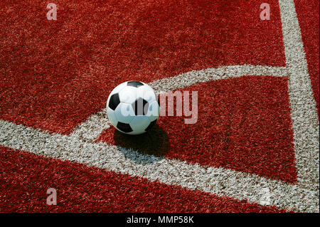 Pallone da calcio su terra rossa, sull'angolo spot, banner di calcio Foto Stock