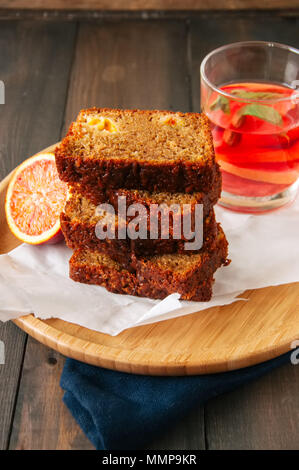 Fette di arancia sterlina vegetariano la torta su un filo rack. Sfondo di legno. Foto Stock