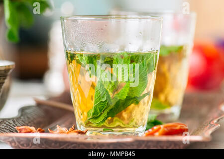 Marocchino tradizionale tè alla menta con date su un vassoio vintage Pietra Bianca dello sfondo. Foto Stock
