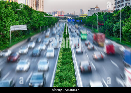 Concetto di interazione tra natura e tecnologia - alberi verdi e dividere la linea verde lungo una strada trafficata di proteggere l'ambiente. Auto su autostrada. Foto Stock