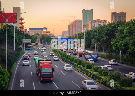 Sera Rush Hour nelle grandi città, ingorghi di traffico da molte automobili su divisa highway road, occupato, la veduta urbana al tramonto. Foto con la sfocatura in movimento Foto Stock