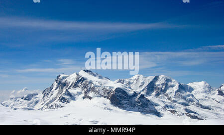 Panorama del paesaggio di montagna delle Alpi svizzere nei pressi di Zermatt in una bella giornata nel tardo inverno sotto un cielo blu Foto Stock