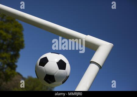 Un bianco e nero di calcio in pelle a croce dei pali della porta Foto Stock