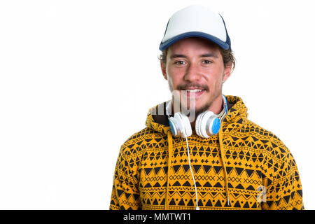 Studio shot del giovane uomo felice sorridente mentre si indossa il cappuccio e hea Foto Stock