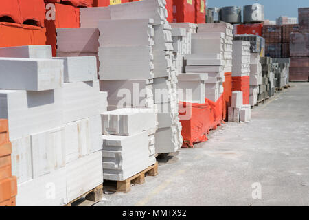 Il cemento cellulare su pallet. I pannelli di parete fatta di aerato autoclavato calcestruzzo su pallet di legno mettere uno sull'altro su un magazzino esterno Foto Stock
