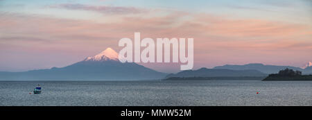 Vista panoramica della sunet sul Lago Llanquihue e coperta di neve del vulcano di Osorno presi da Puerto Varas, Los Lagos Regione, Patagonia, Cile Foto Stock