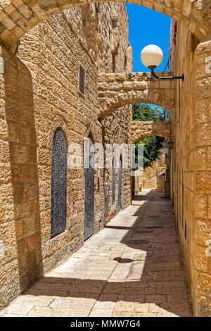Strada stretta tra le vecchie case di pietra nel quartiere ebraico nella città vecchia di Gerusalemme, Israele (composizione verticale). Foto Stock