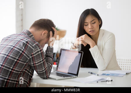 Sottolineato triste asiatici e caucasici scioccato partner informazioni sulla società Foto Stock