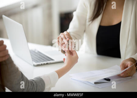 Agente immobiliare dando donna chiave per la nuova casa e acquisto di immobili Foto Stock