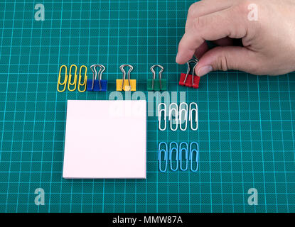 Fermagli per carta e annotare sul foglio di verifica sfondo verde Foto Stock