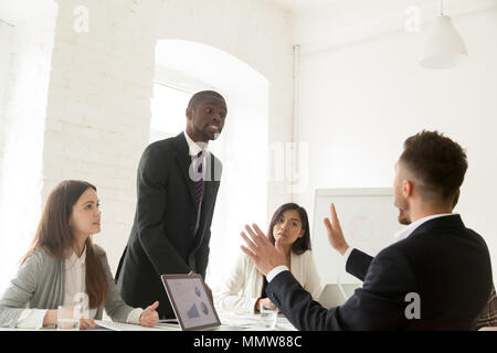 Rude arrabbiato imprenditore africana sostenendo le grida al collega dur Foto Stock